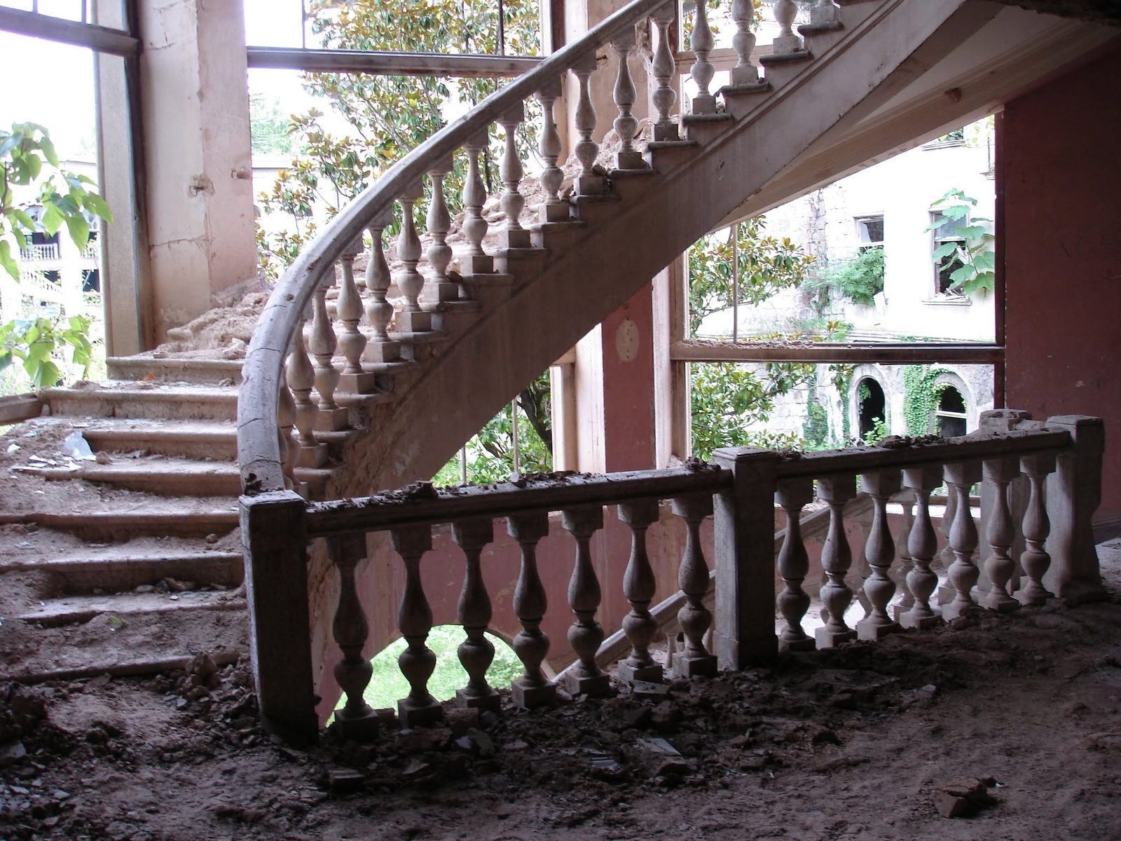 Un escalier en colimaçon dont les barreaux de la rampe tiennent encore.