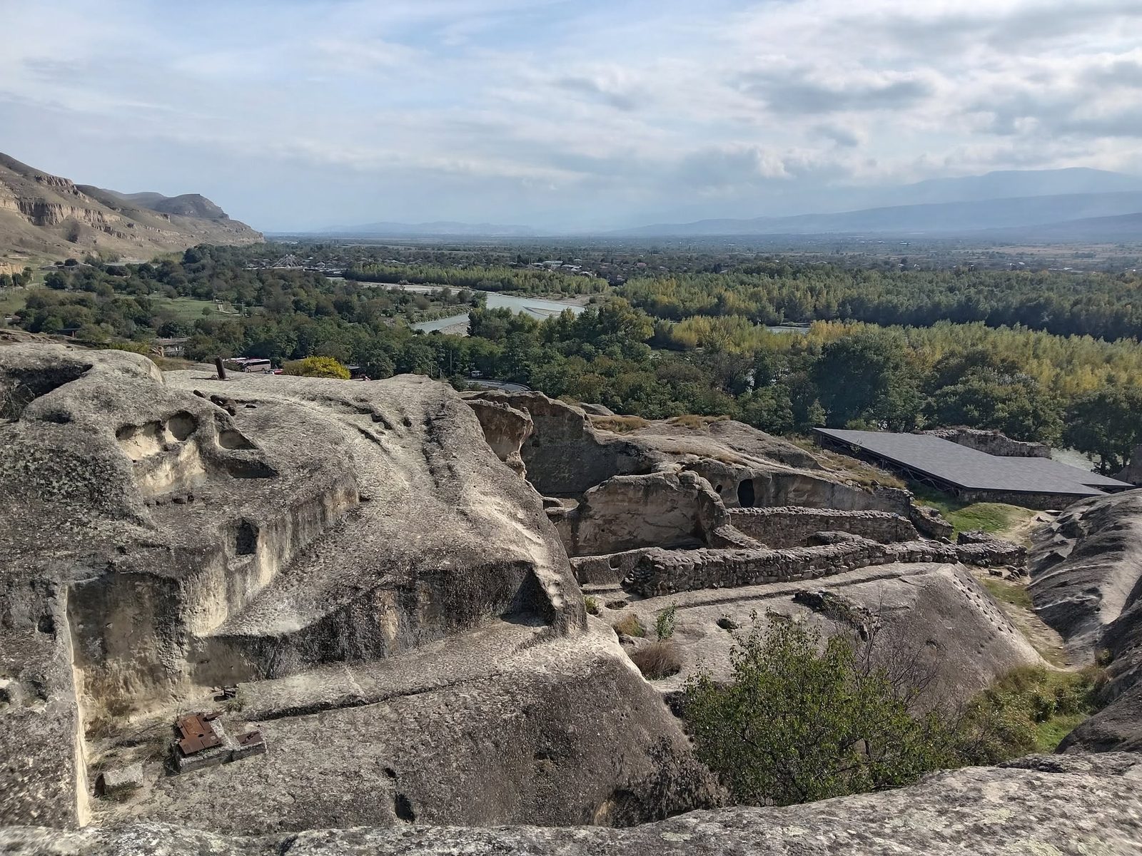 La ville troglodytique vue d'en haut : la roche, ses ruelles et, derrière, la vallée.